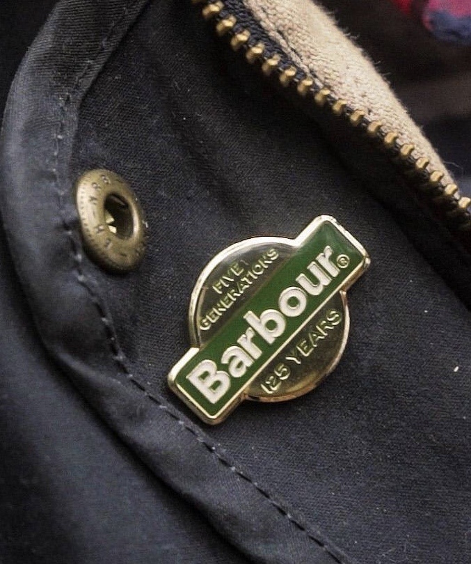 Barbour Five Generations 125 Years pin badge on a wax jacket