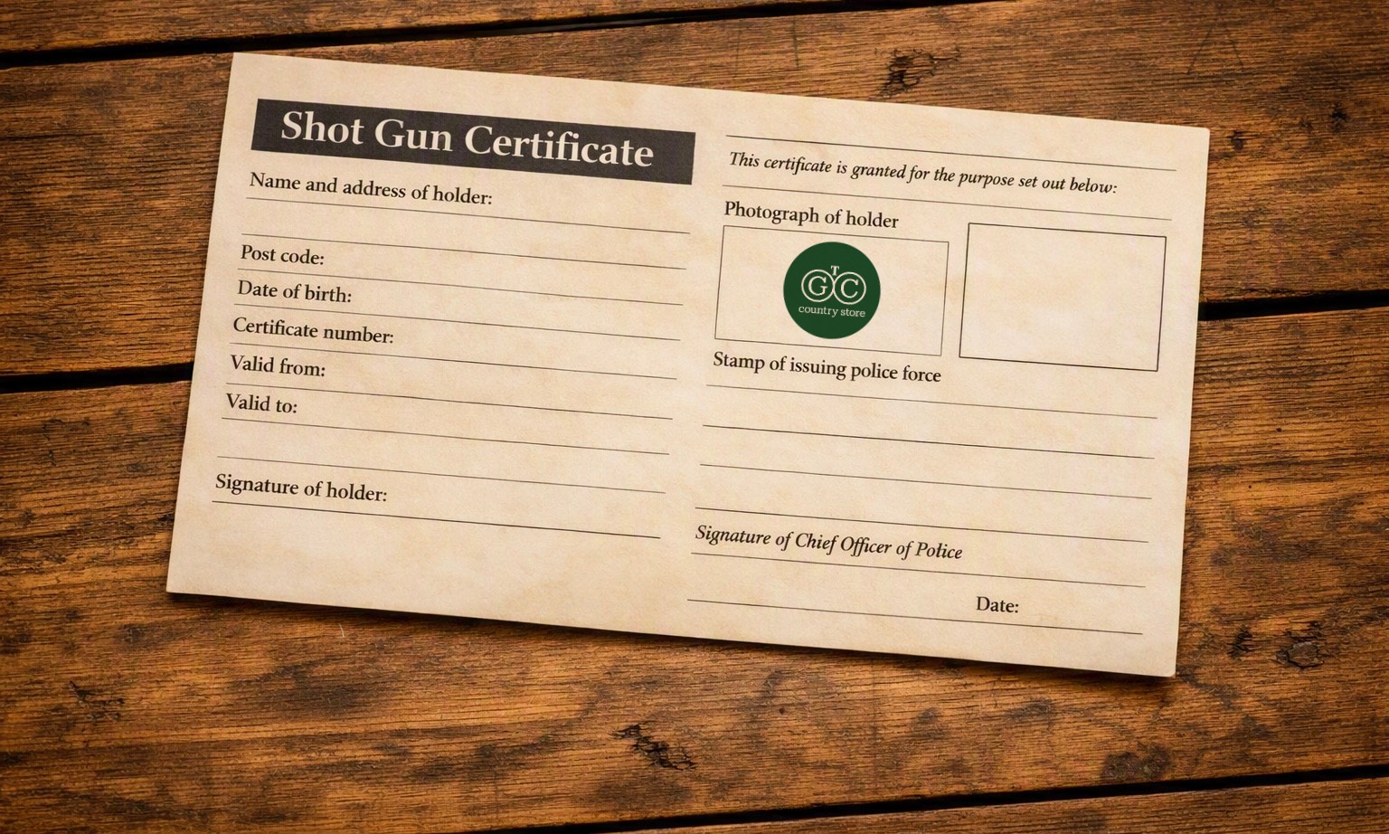 Shotgun certificate on a wooden table with The Gun Cupboard logo in the holder photo box